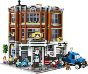 Toy city street scene with buildings, vehicles, and people on a white background
