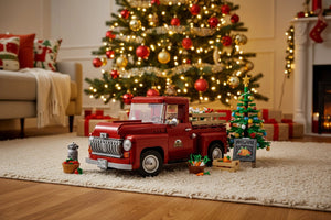 Red toy truck in a living room with a decorated Christmas tree and presents.