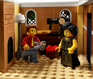 Two LEGO figures in a kitchen setting with a coffee machine and oven.