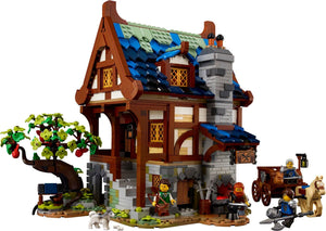 Toy model of a medieval-style house with characters and a tree on a white background