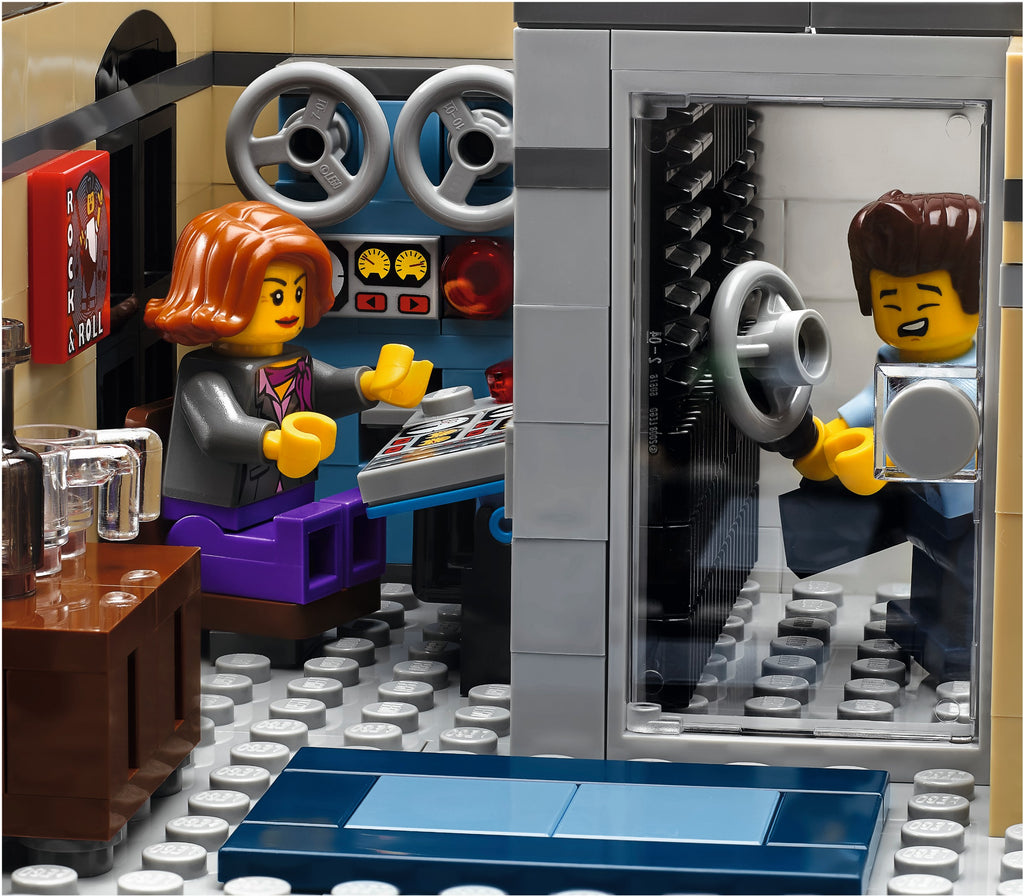 LEGO model of a car interior with two minifigures inside, one driving and one sitting.