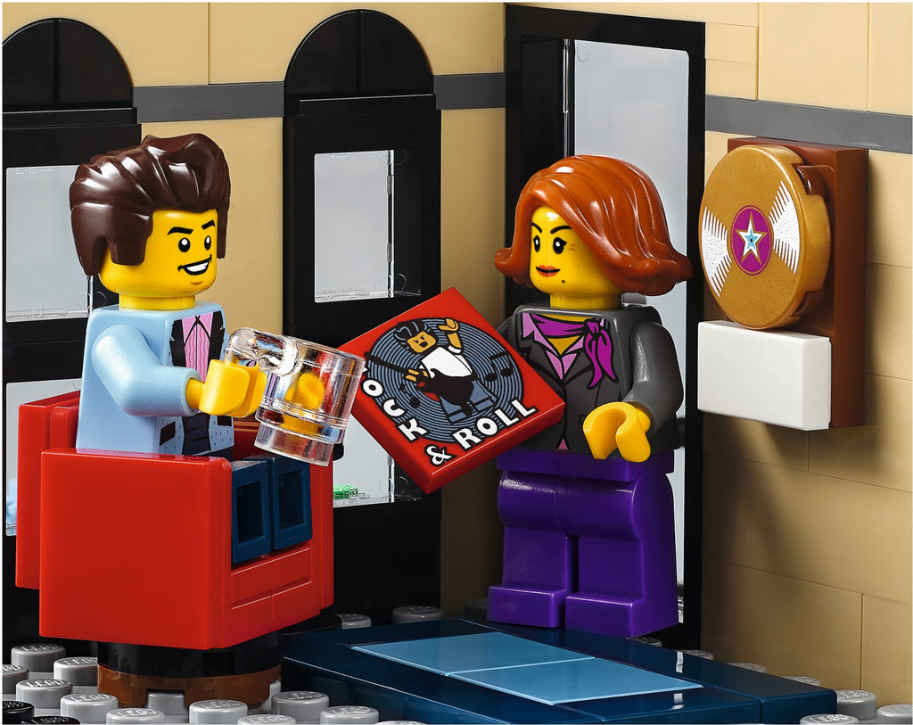 Two LEGO figures in a room with a jukebox and wall decorations.