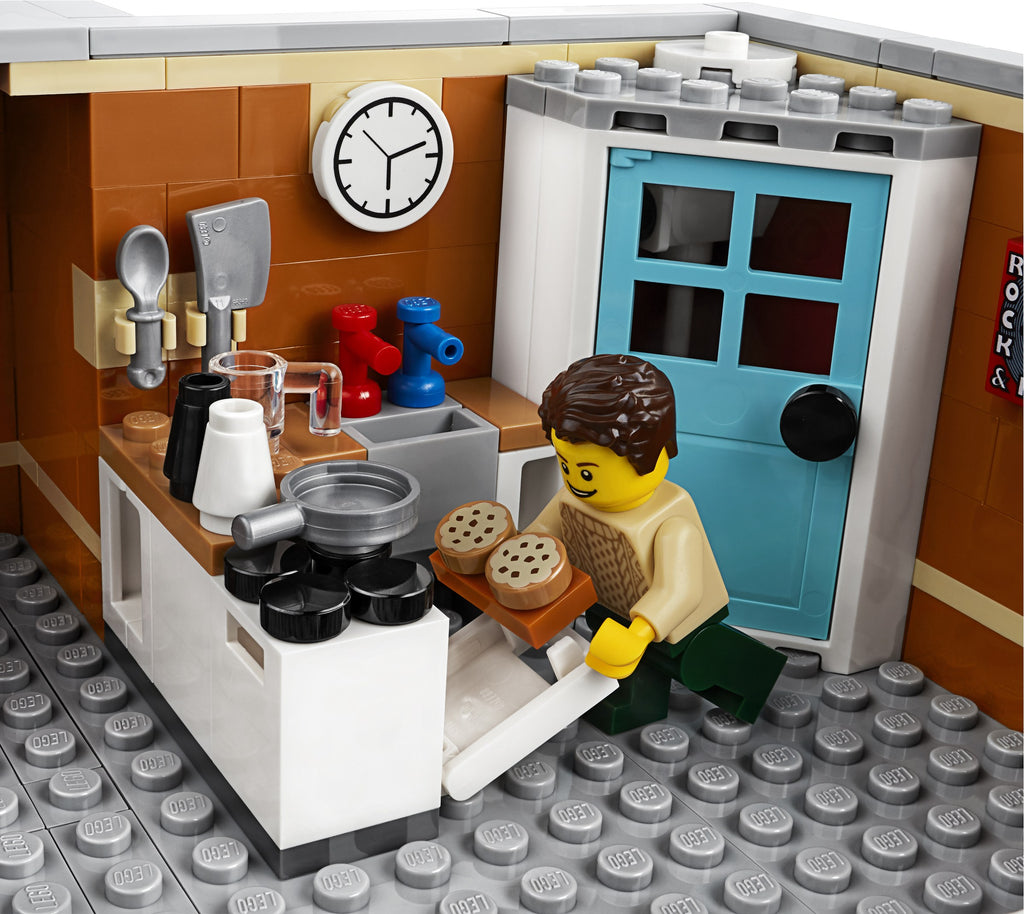 LEGO kitchen set with a character holding bread, clock on wall, and various kitchen items.