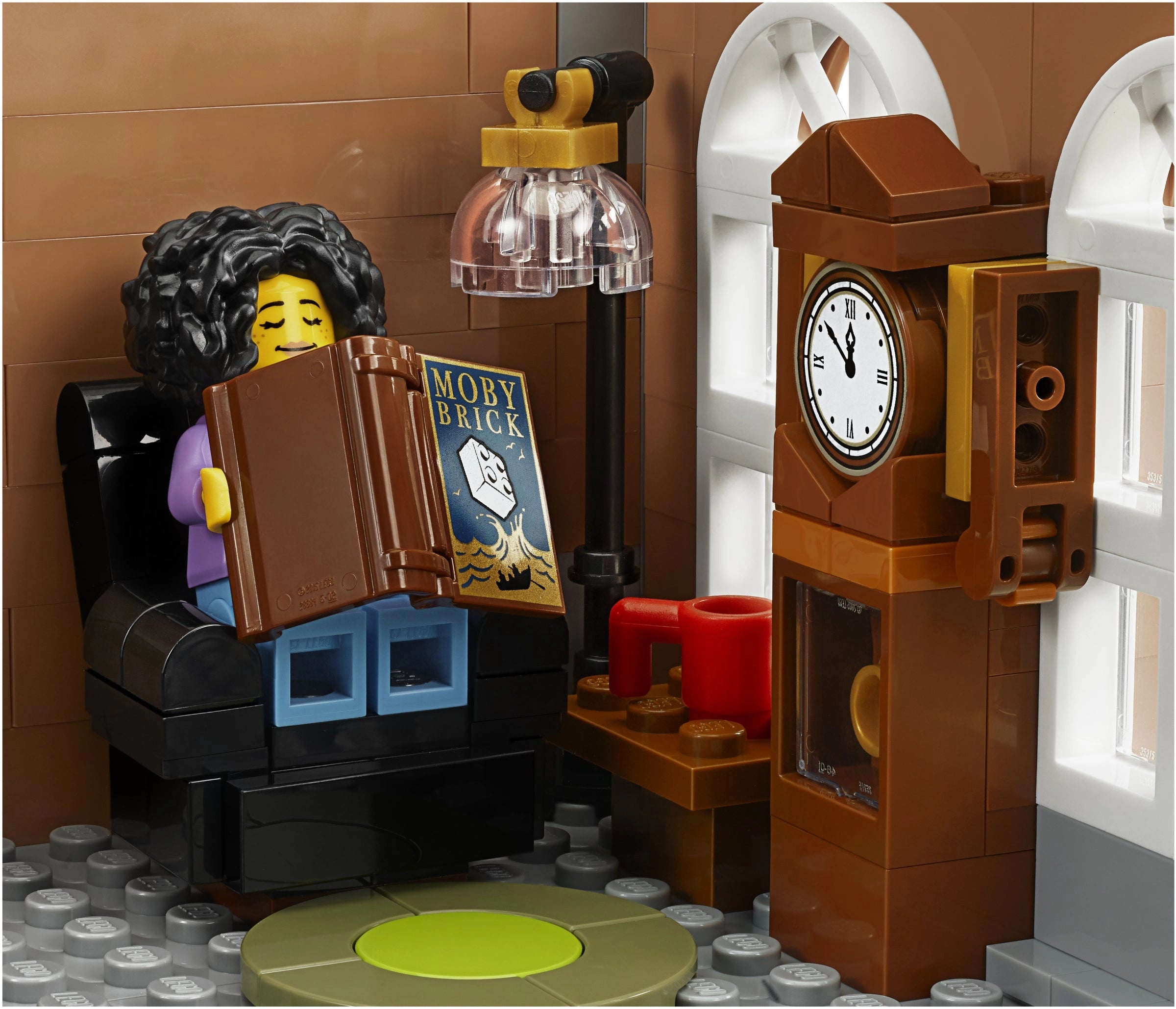 LEGO figure reading a book next to a clock and lamp in a room setting.
