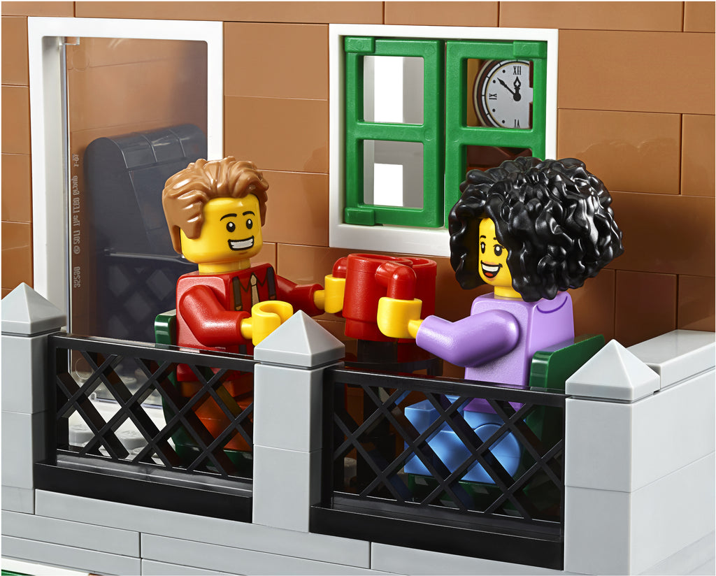 Two LEGO figures in a small fenced area with a clock on the wall.