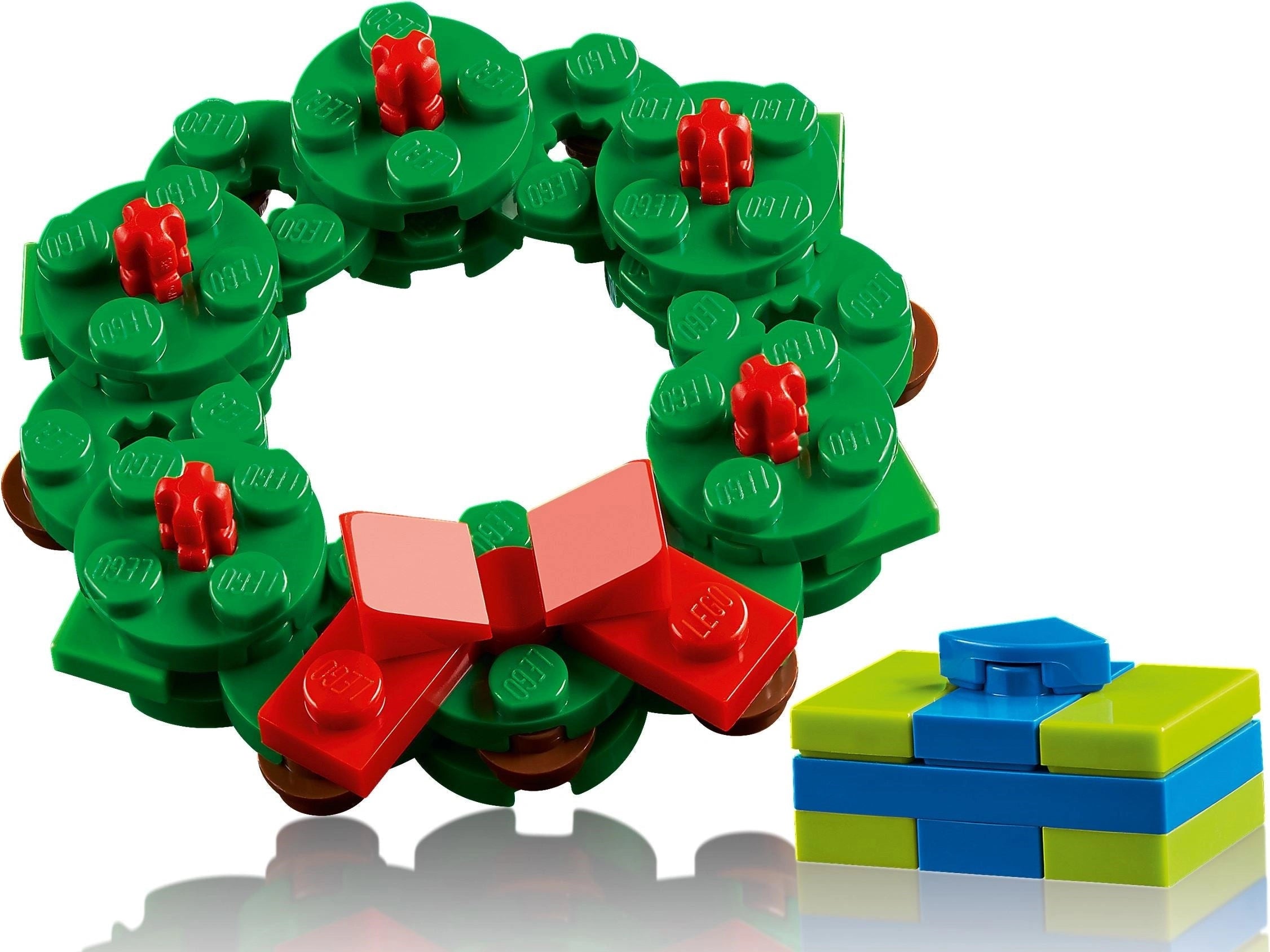 Christmas wreath made of green building blocks with red details and a blue gift box on a white background