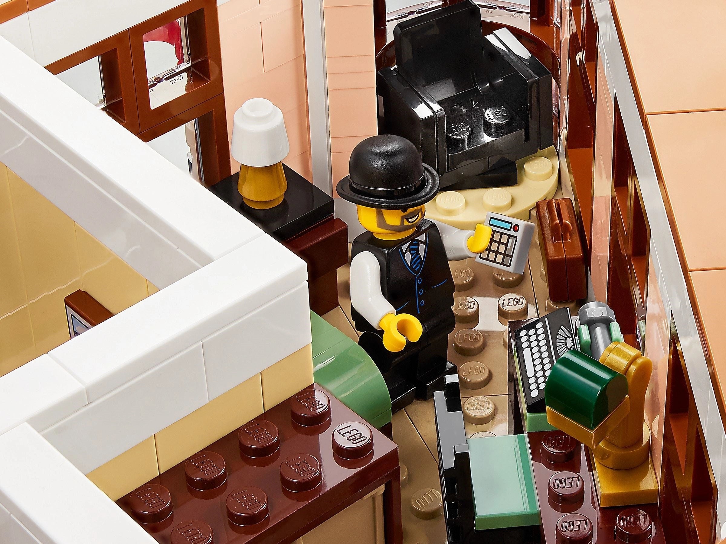 Close-up of a LEGO scene with a character in a bar setting, including a cash register and drinks.