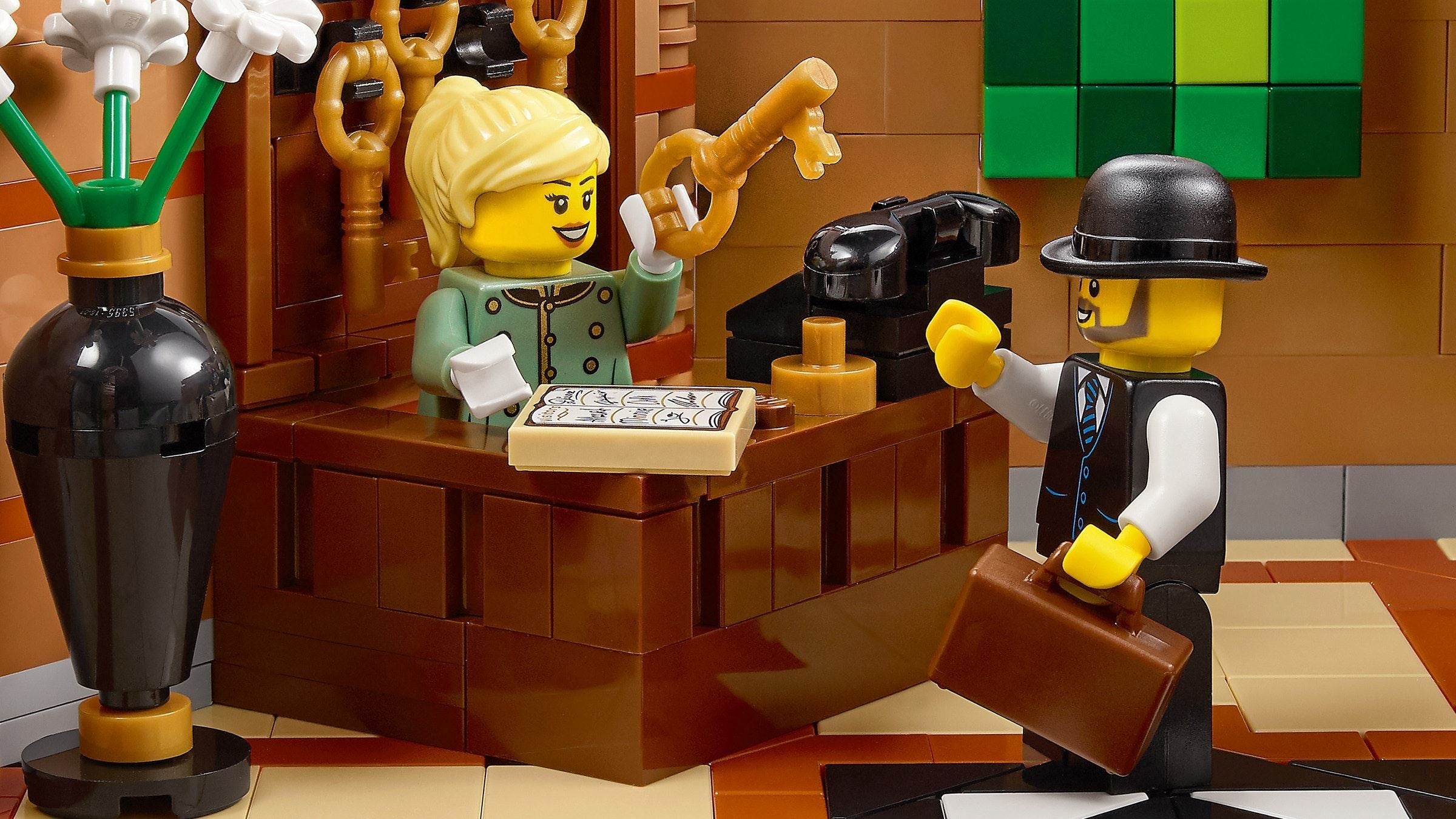 LEGO figures in a scene with a desk and various items