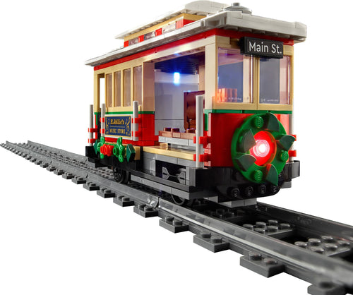 Toy train set on tracks with a detailed car and lights on a white background