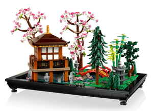 LEGO model of a Japanese-style building with cherry blossom trees and greenery on a white background