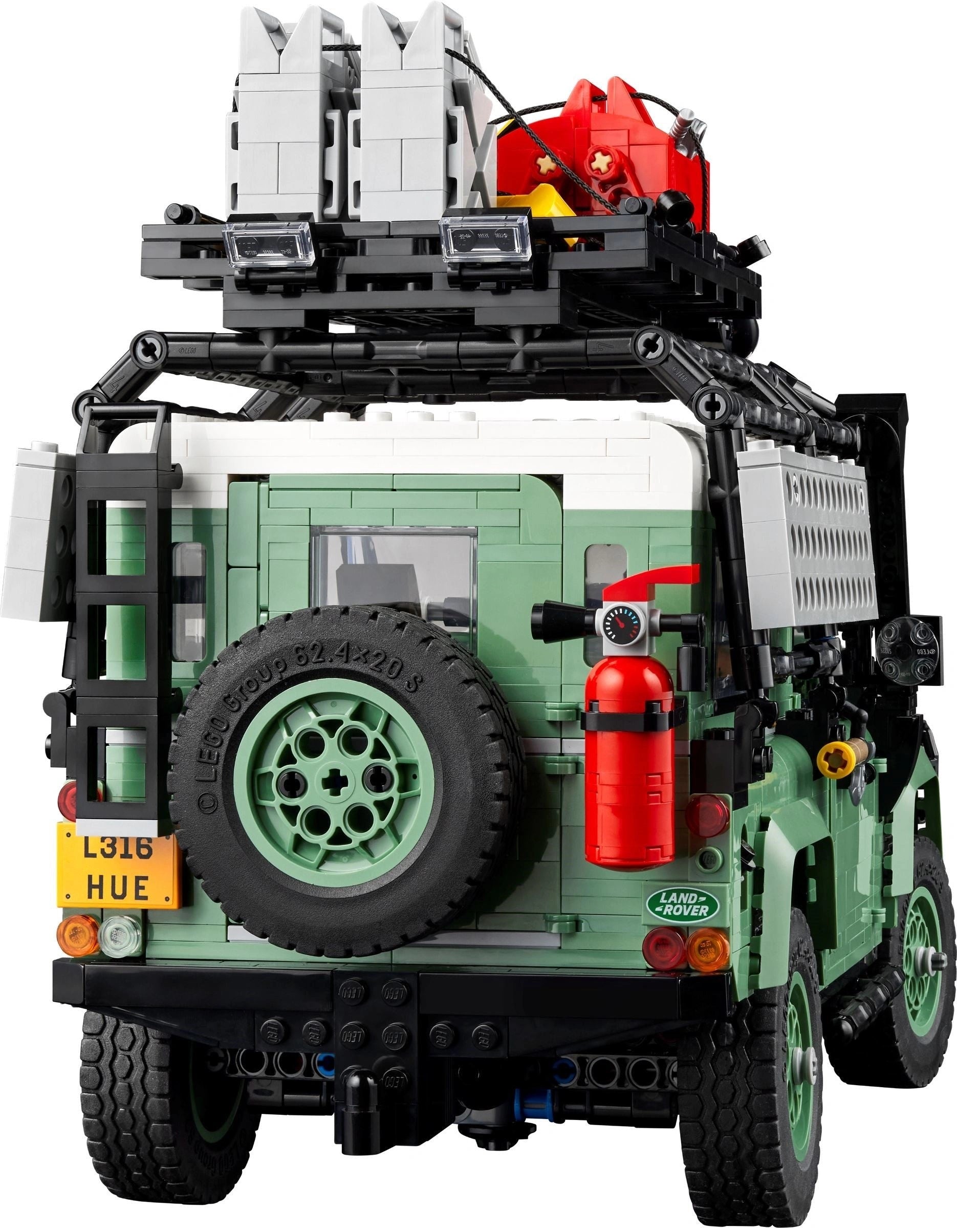 LEGO model of a vehicle with green body, black tires, and red fire extinguisher on a white background