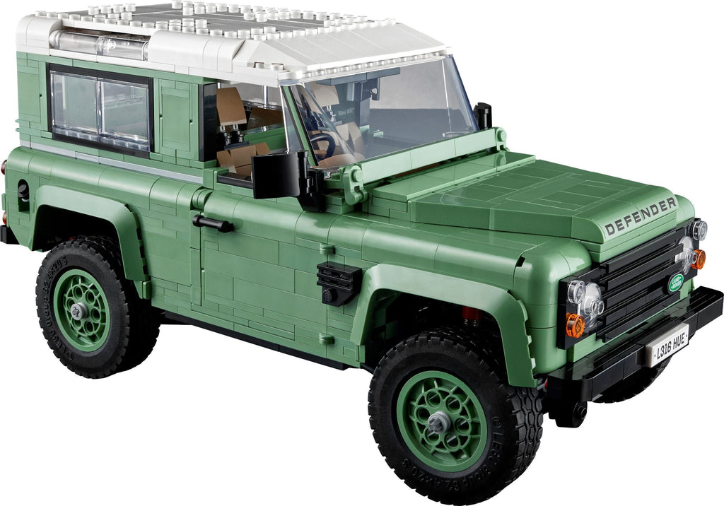 Green model of a Land Rover Defender on a white background