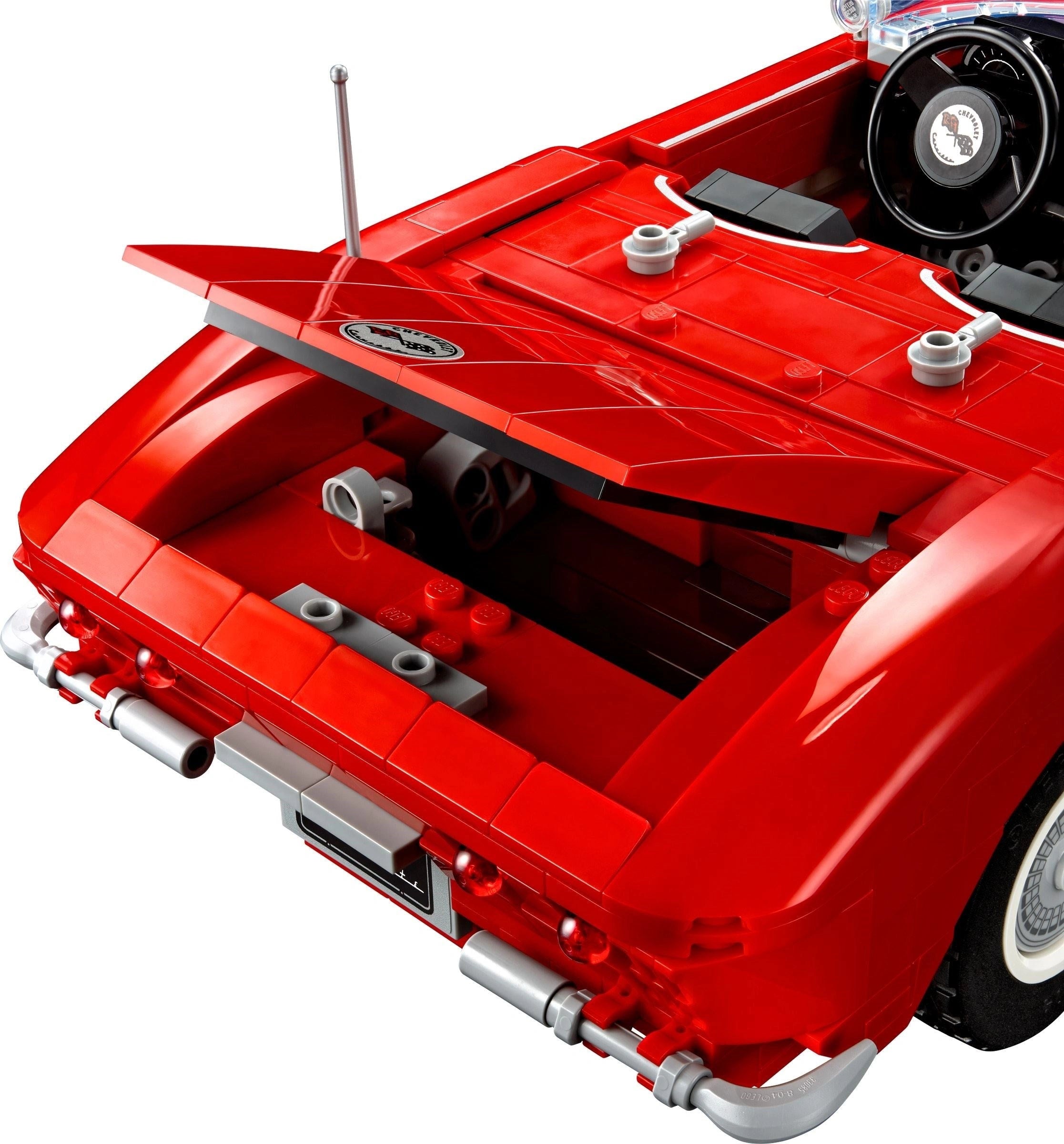 Close-up of a red car model with visible mechanical details on a white background