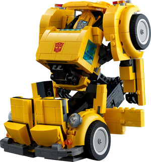 Yellow robot toy with a visible Transformers logo on a white background