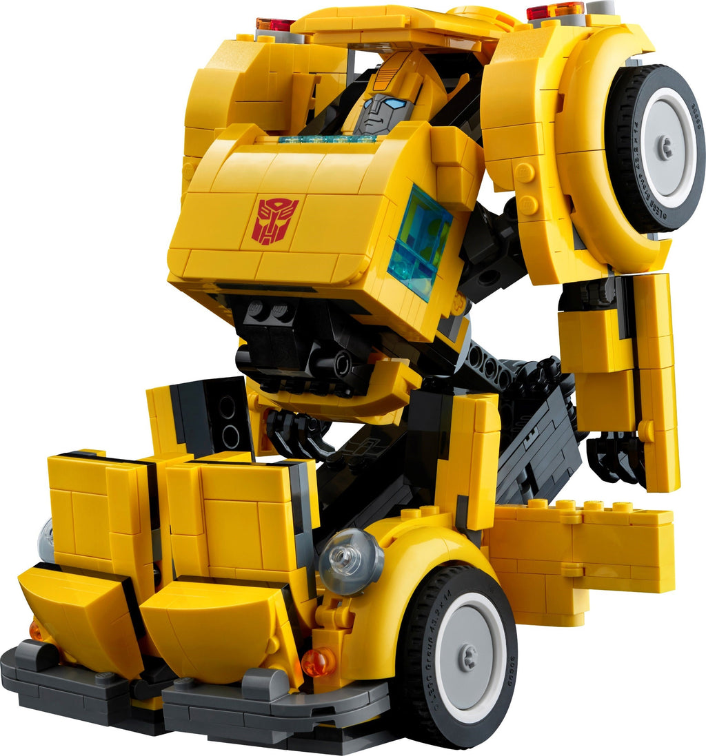 Yellow robot toy with visible Transformers logo on a white background