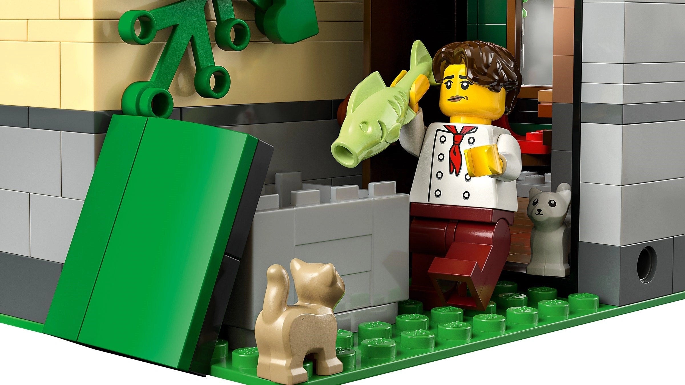 LEGO figure of a person with a dog and a fish, standing next to a green door.