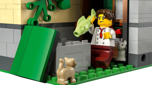 LEGO figure of a person with a dog and a fish, standing next to a green door.