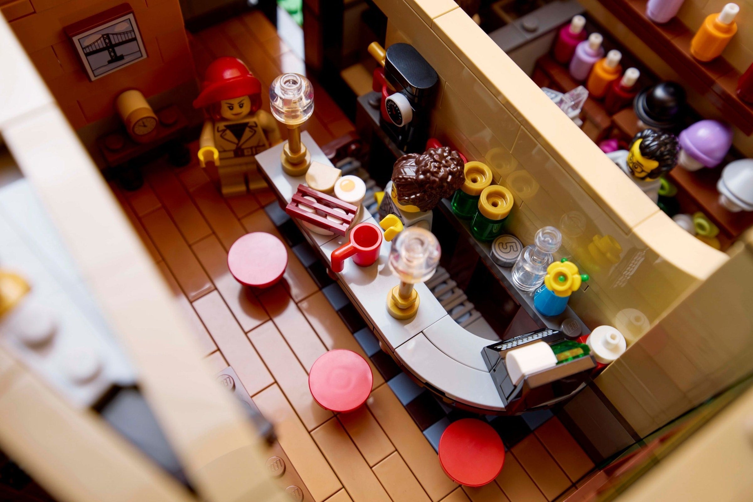 Toy kitchen set with LEGO figures and furniture, including a refrigerator, stove, and dining table.