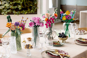 Decorative table setting with colorful flower arrangements and tableware.