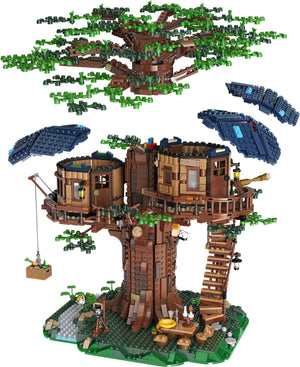 Treehouse model made from interlocking bricks with greenery on a white background