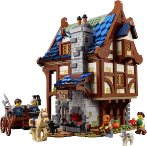 LEGO model of a medieval-style house with characters and a cart on a white background