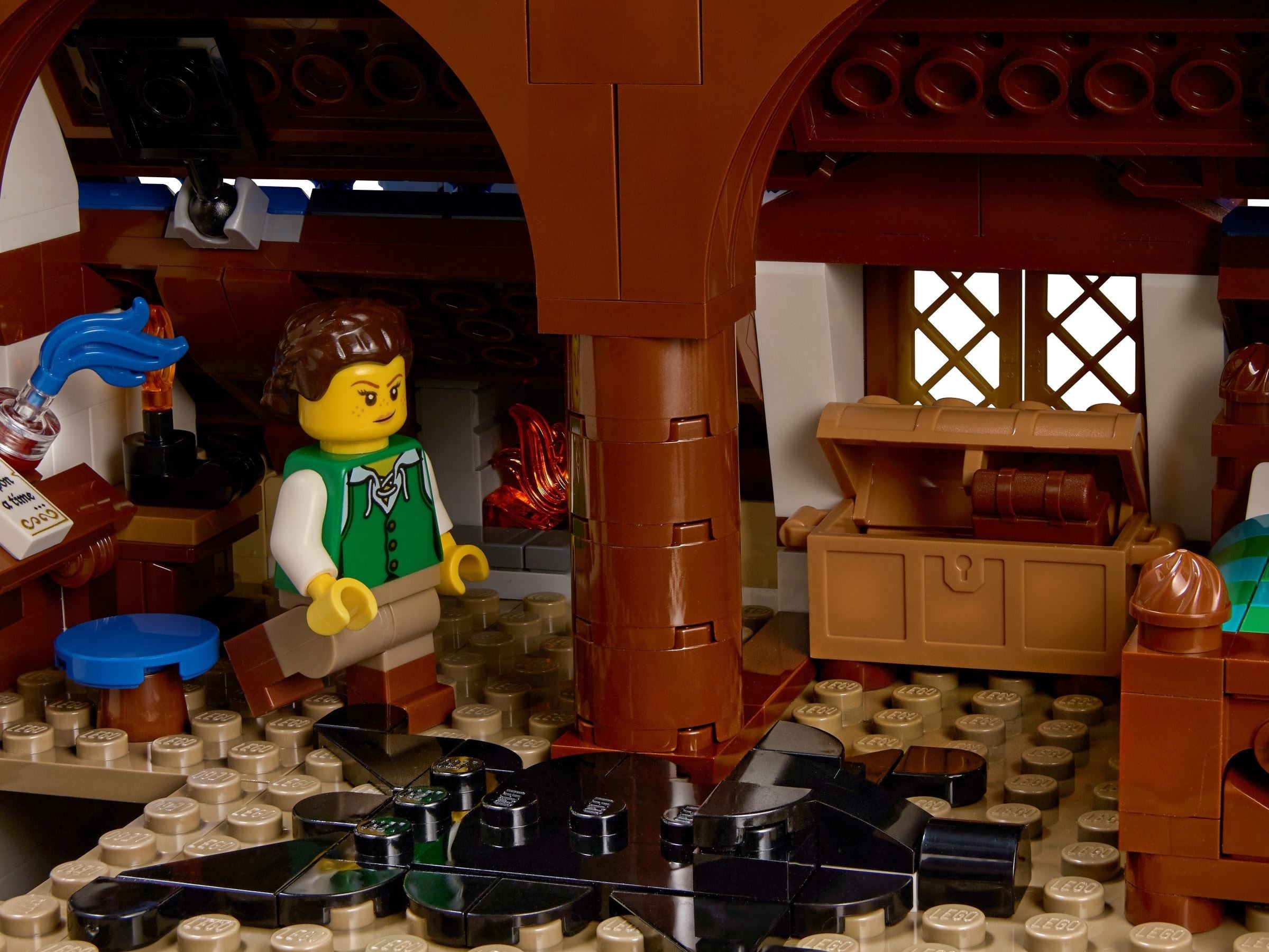 LEGO figure in a rustic interior setting with wooden furniture and a chest.