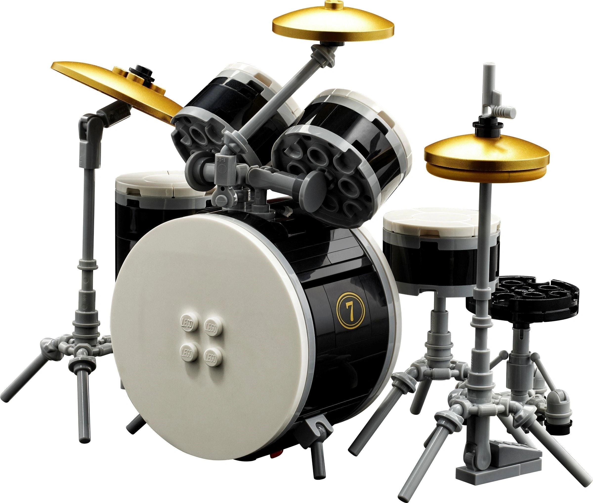 LEGO drum set with black bass drum, white snare drum, and gold cymbals on a white background