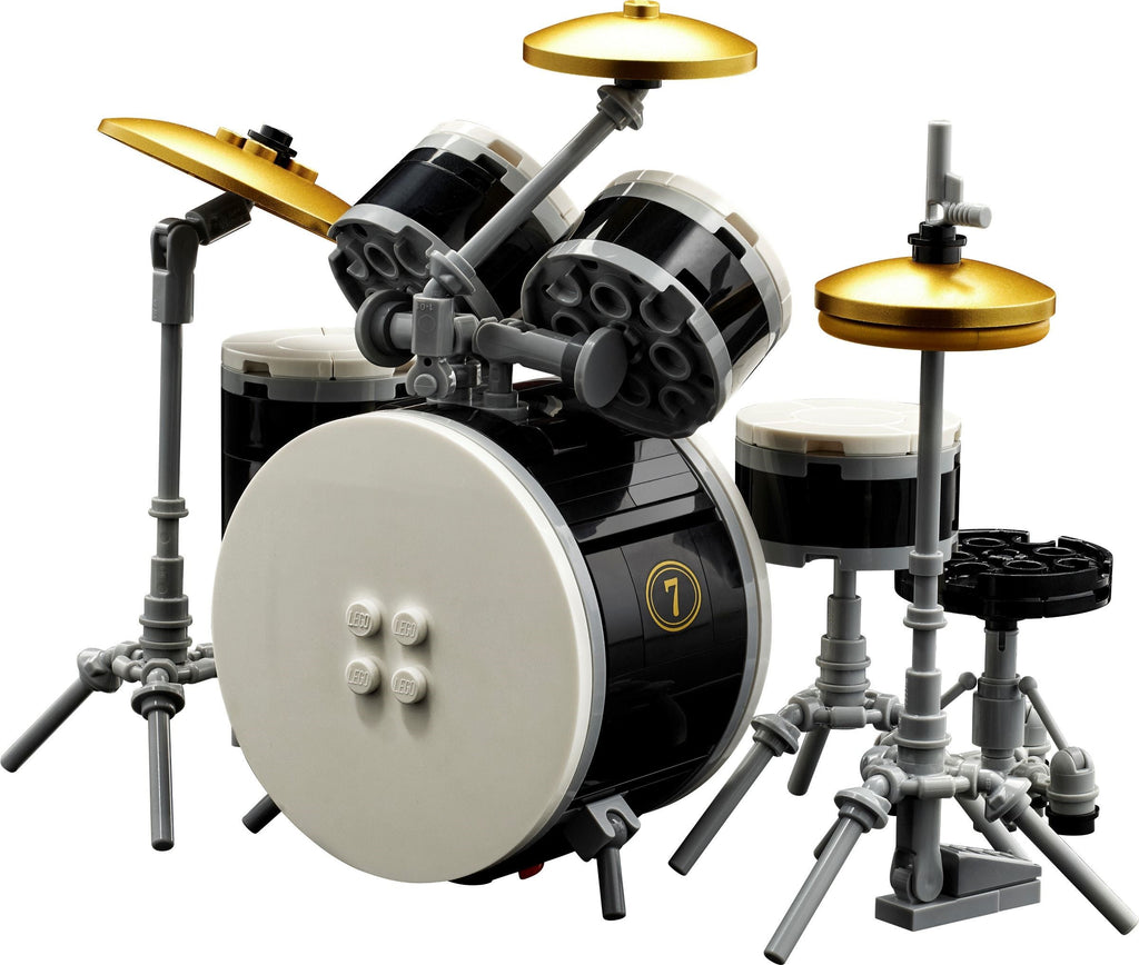 LEGO drum set with black bass drum, white toms, and gold cymbals on a white background