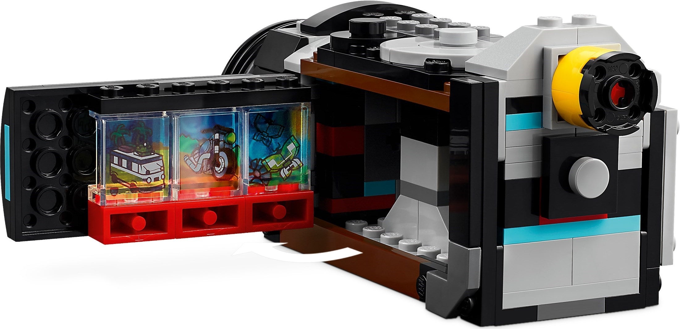 Toy camera model made of interlocking bricks with open compartment showing miniature scene inside.