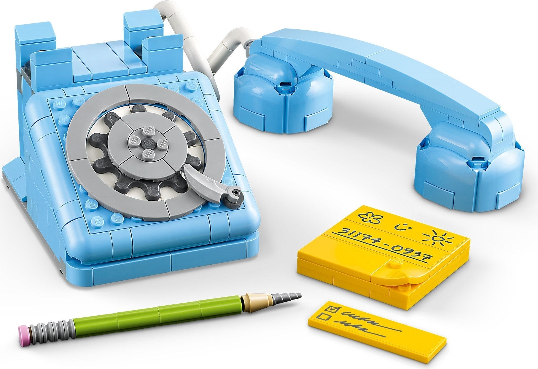 Toy telephone set with blue base, gray rotary dial, yellow phone book, and pen on a white background