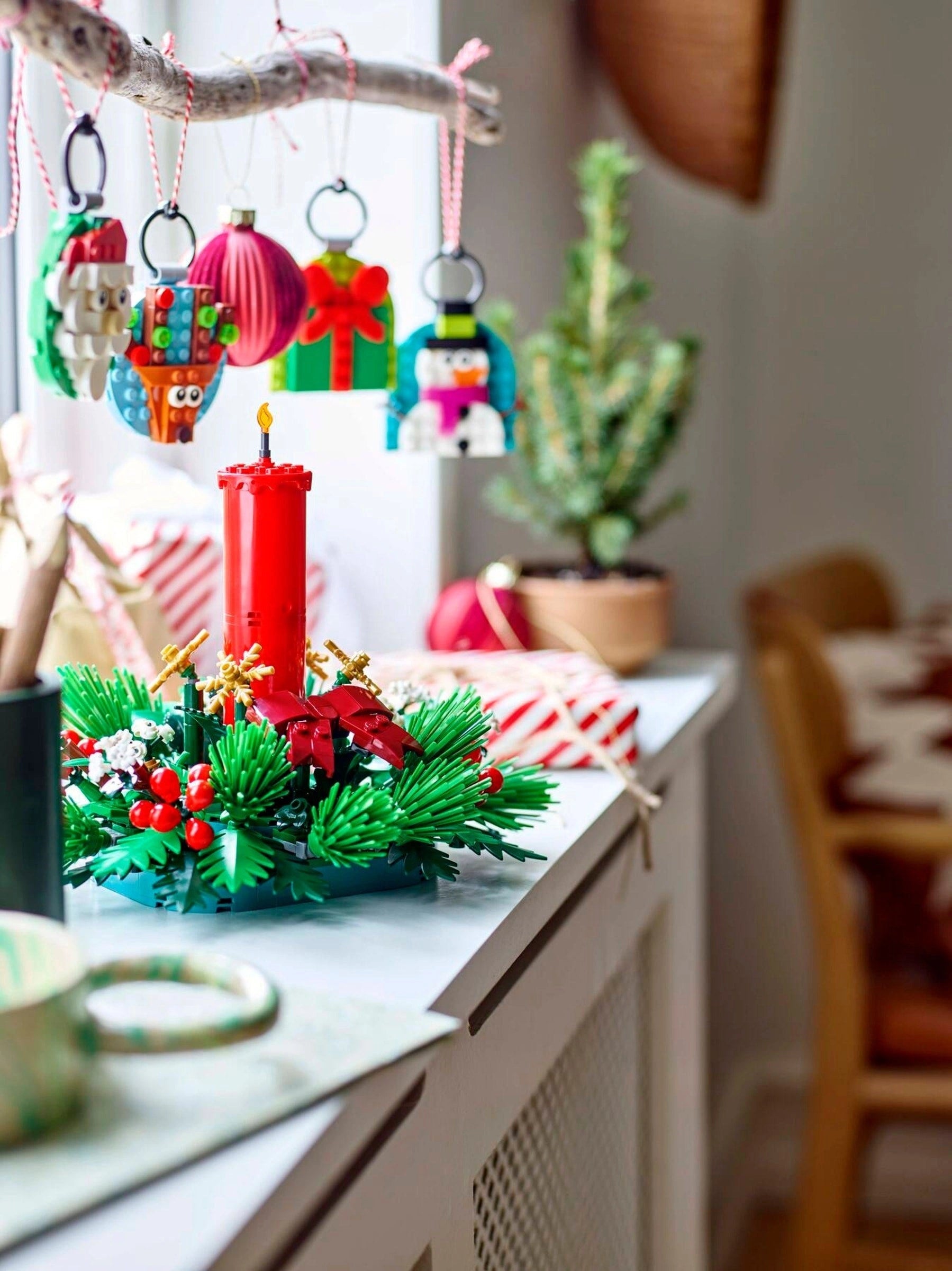 Decorative Christmas wreath with candles and ornaments on a kitchen counter.
