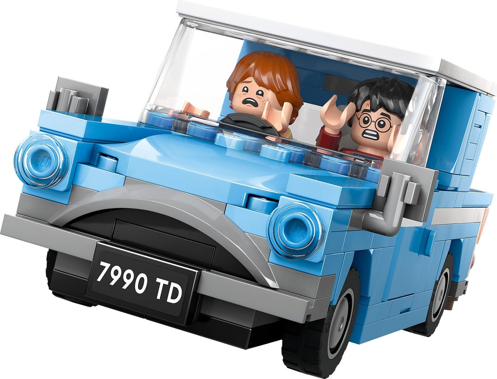 Toy car model with two figures inside, resembling a classic vehicle, on a white background.