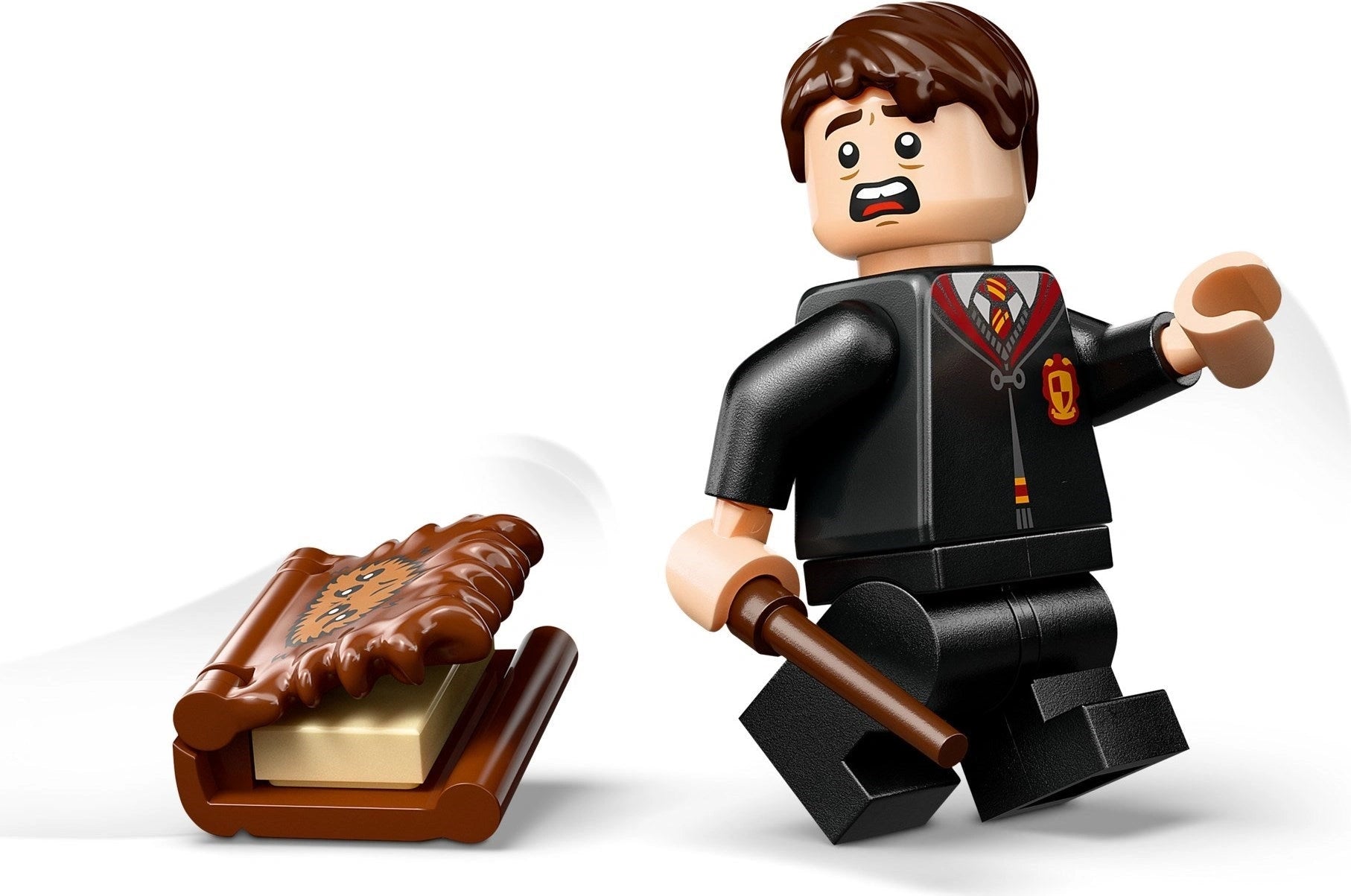 LEGO minifigure of a character from a popular franchise holding a wand and a chocolate frog.