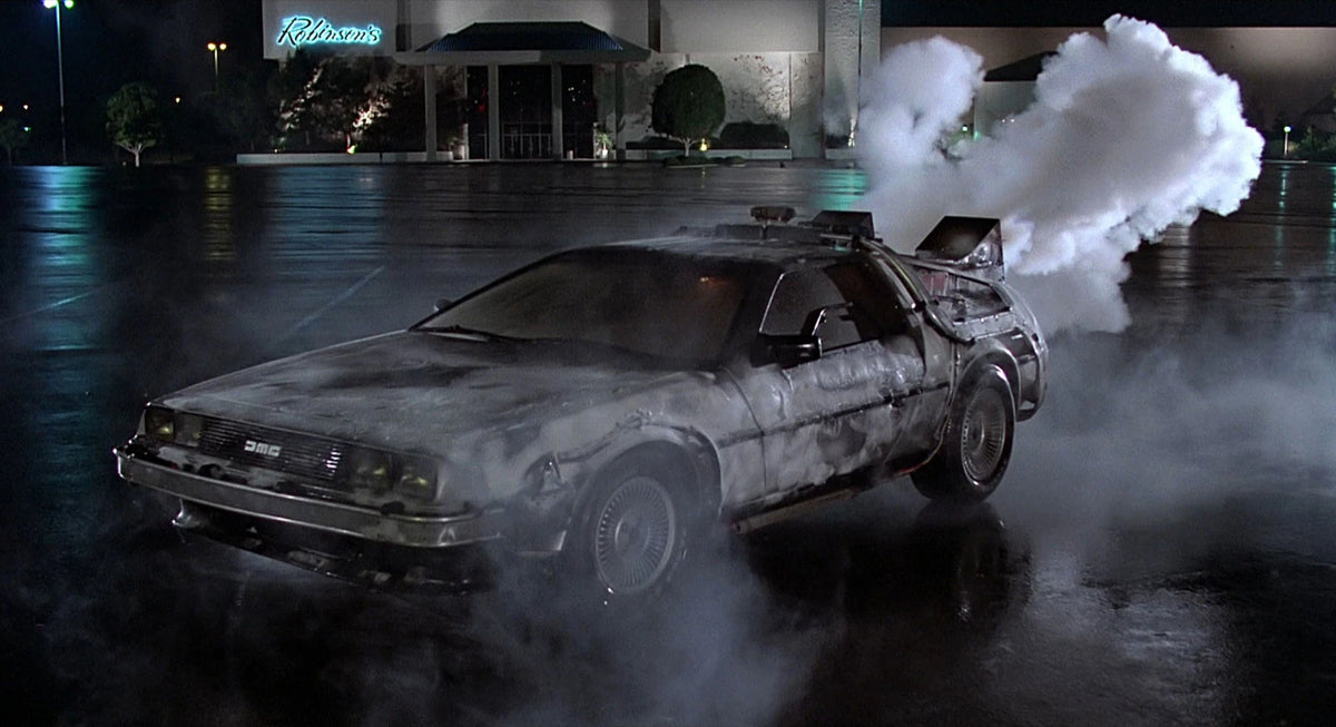 Vintage car with smoke effects on a wet road at night, resembling a scene from 'Back to the Future'.