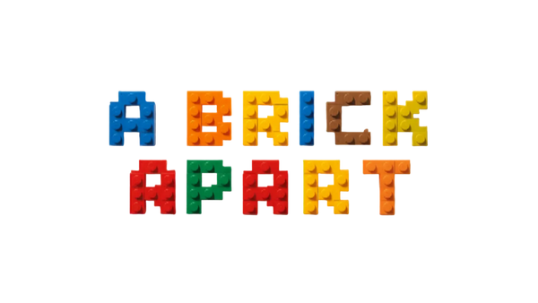 Colorful building blocks spelling 'A Brick Apart' on a textured surface.